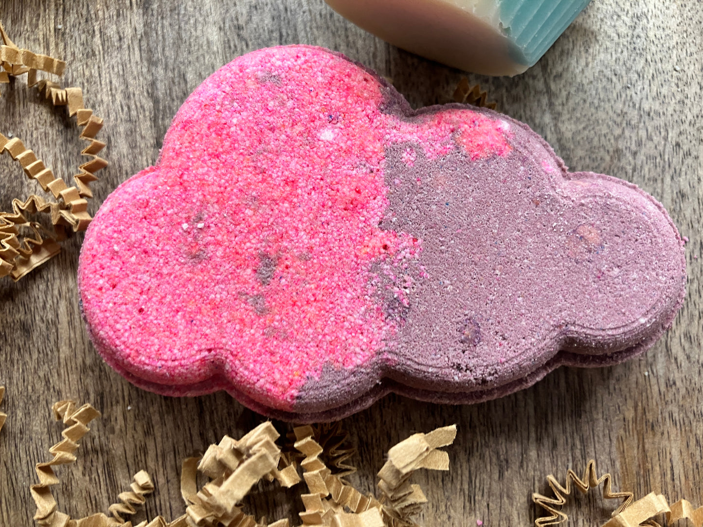 Hot pink and purple bath bomb shaped like a puffy cloud.