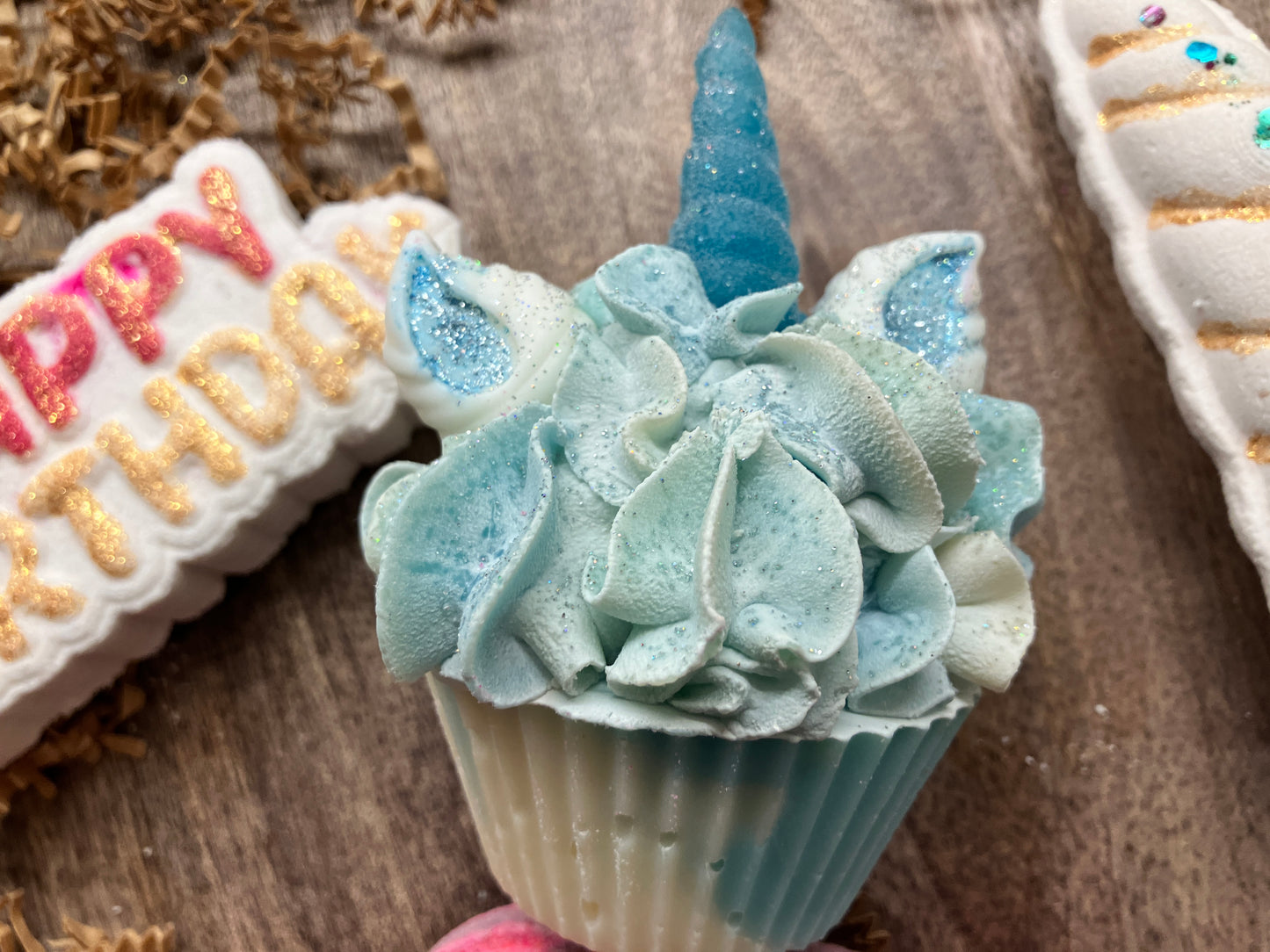 Close up of Unicorn Soap has a frosted appearing teal horn with teal painted ears and shaped like a cupcake.
