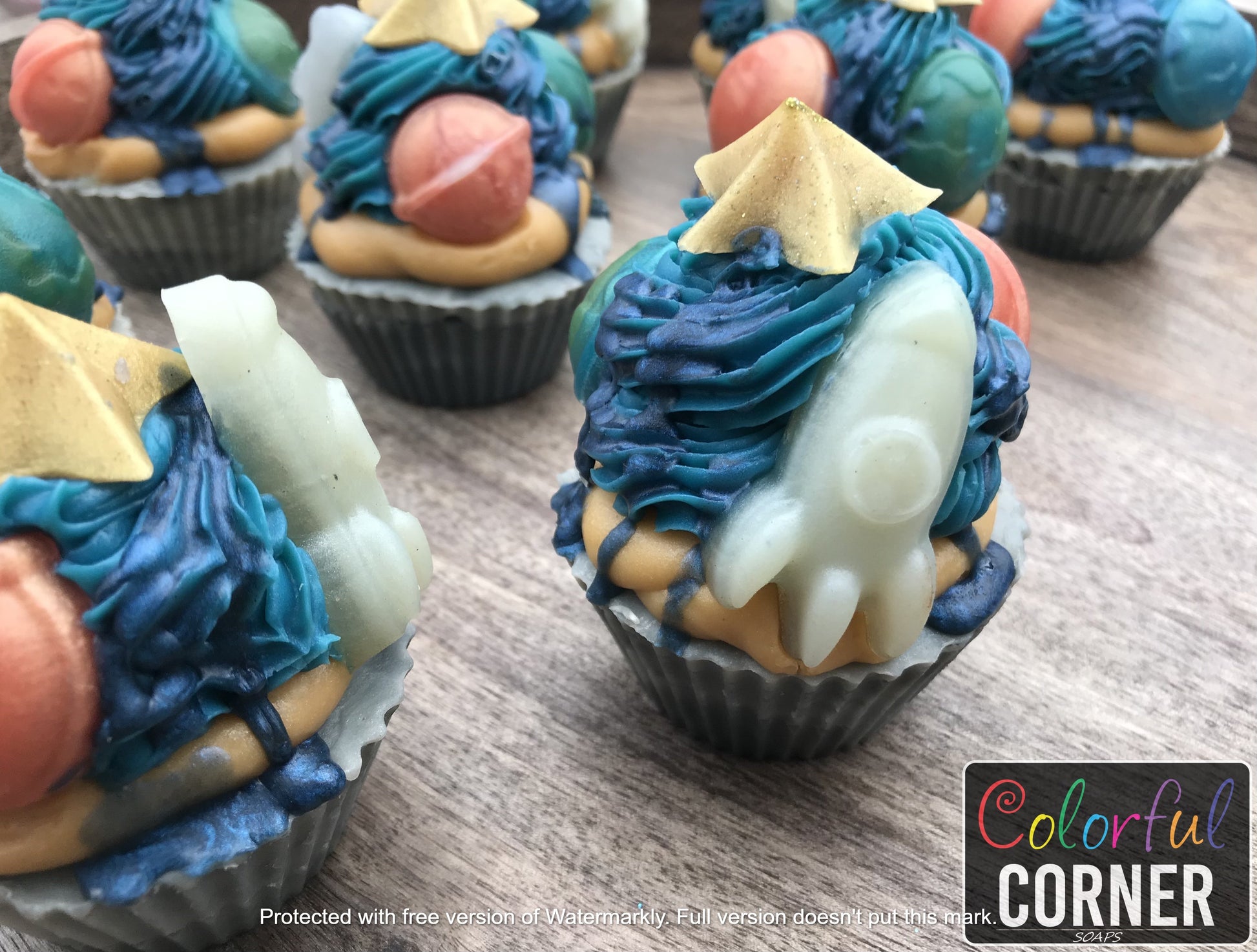 Zoomed in picture of cupcake soaps standing upright shown focused on space ship.