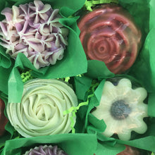 Load image into Gallery viewer, Zoomed in photo of four soaps. Lilac cupcake, Molded Rose, Pipped Green Rose, and Molded Daisy. 
