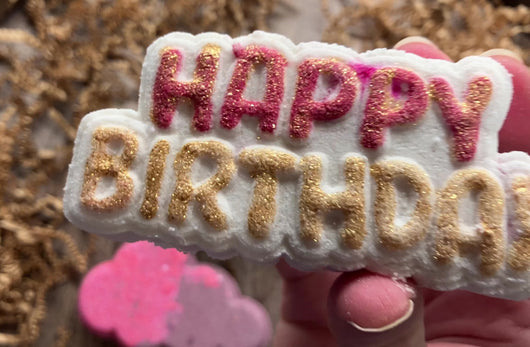 Small video of clean hand and nails placing cupcake soap in the middle of display.