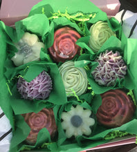 Load image into Gallery viewer, Zoomed out photo of opened box shows green tissue around each soap giving the appearance of a floral bouquet. 
