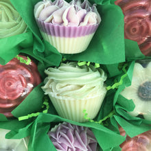 Load image into Gallery viewer, Sides of two cupcake floral soaps displayed. Top image has purple top and white bottom. Bottom image has frosted green rose and cream colored base. 
