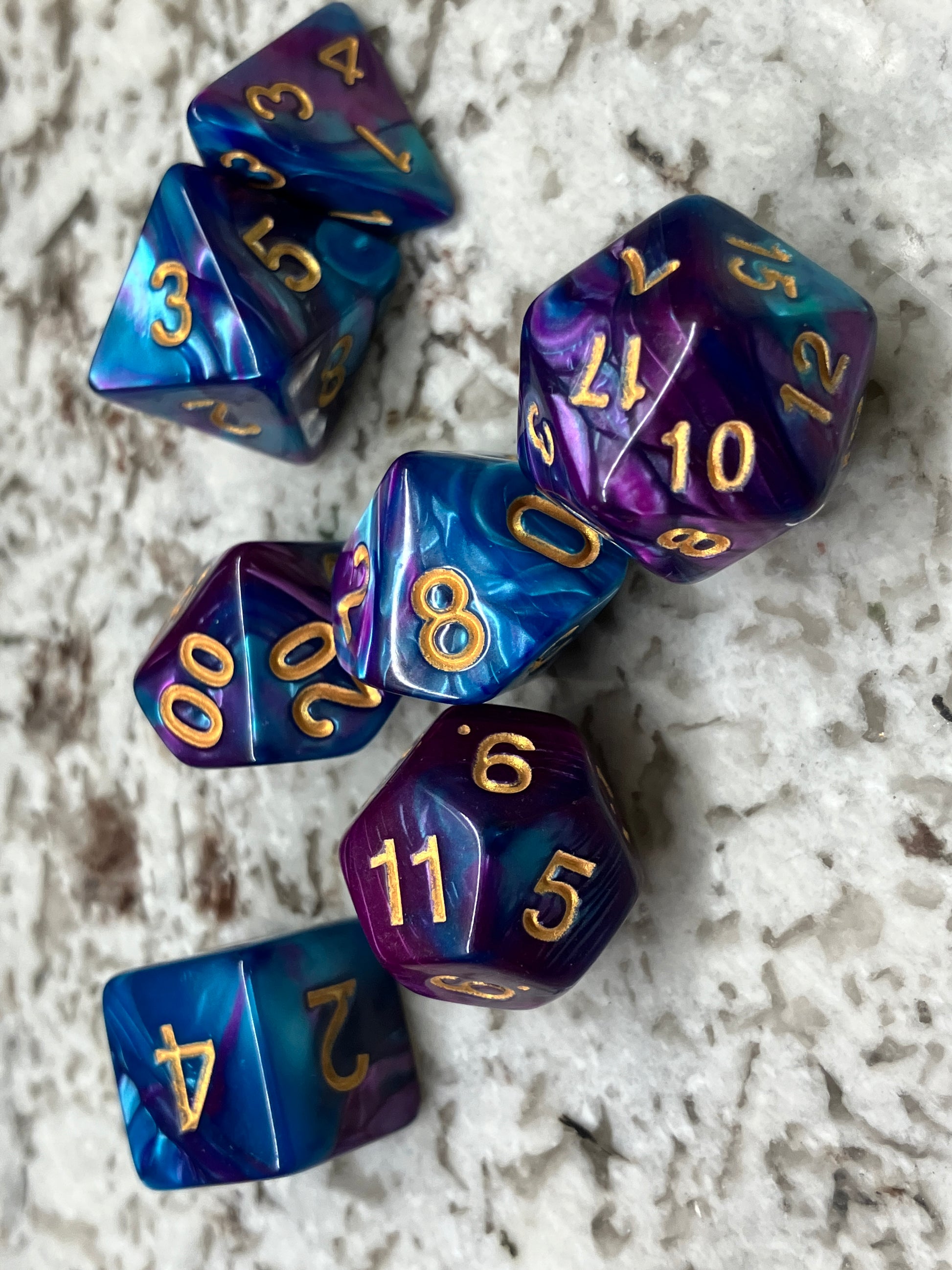 Purple and blue dice with gold numbering.