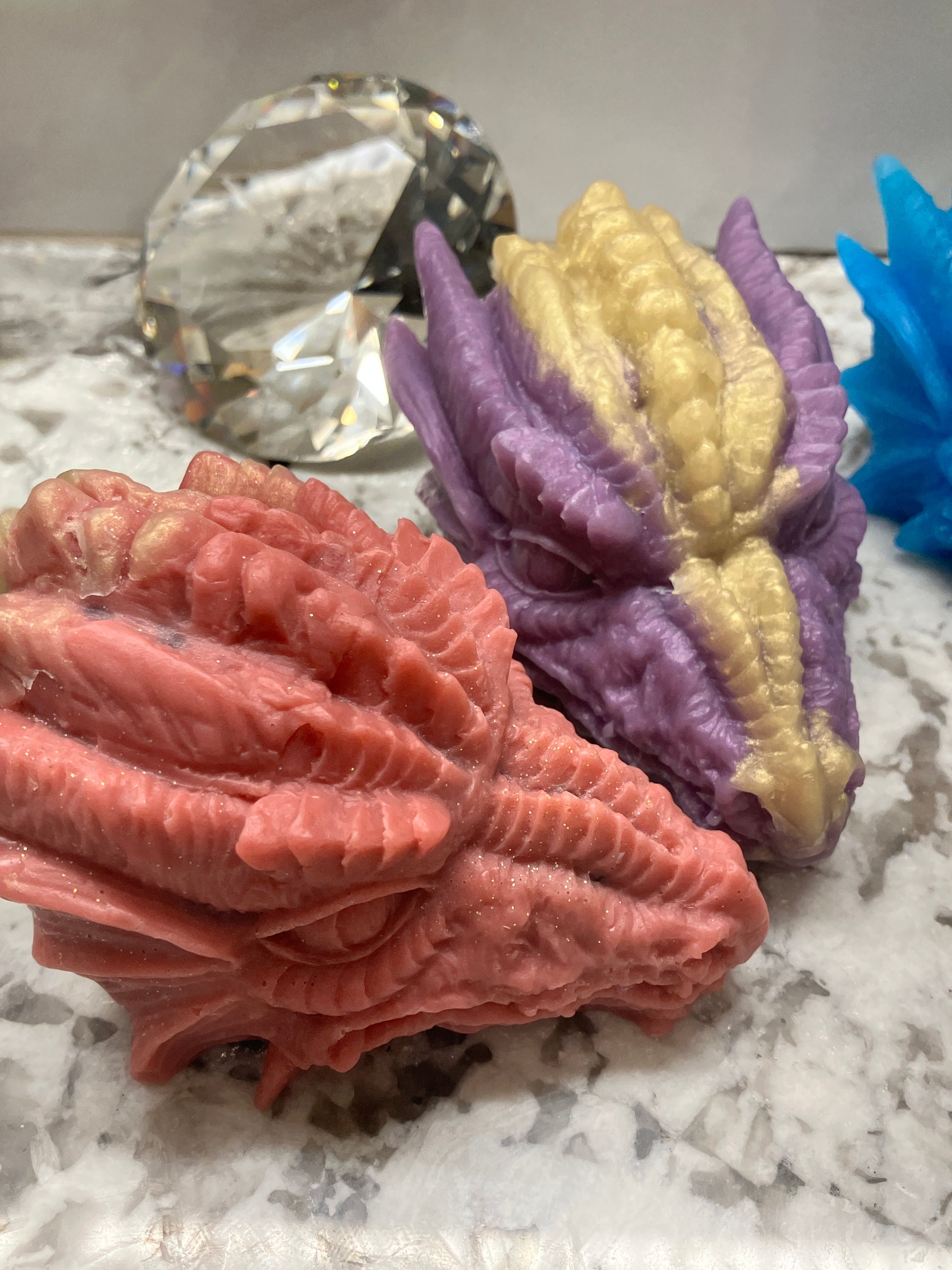 Dragon heads red and purple shown with large gem in background for display only.
