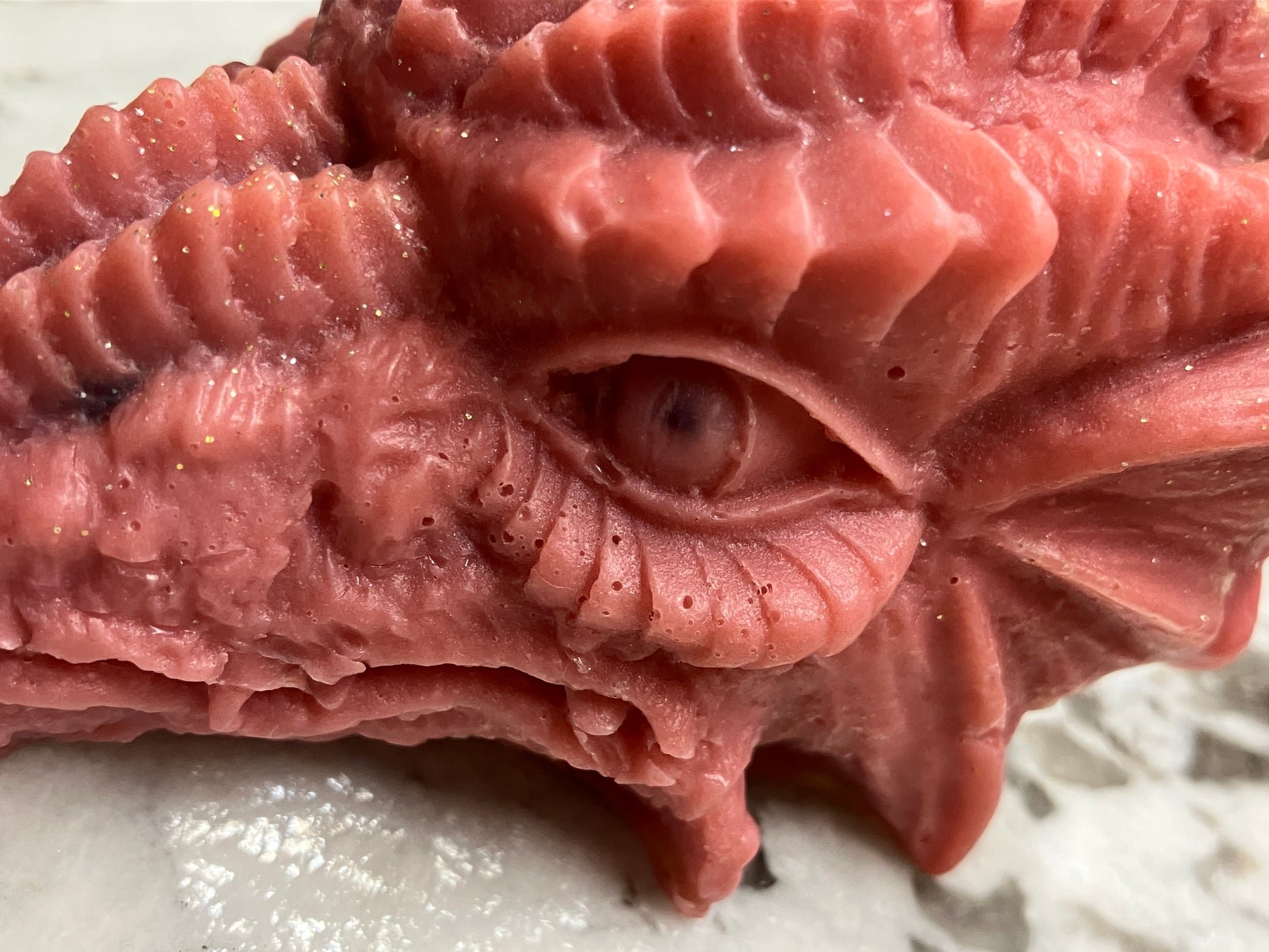 Zoomed in side view of red dragon head showing the level of detail on the eye and scales.