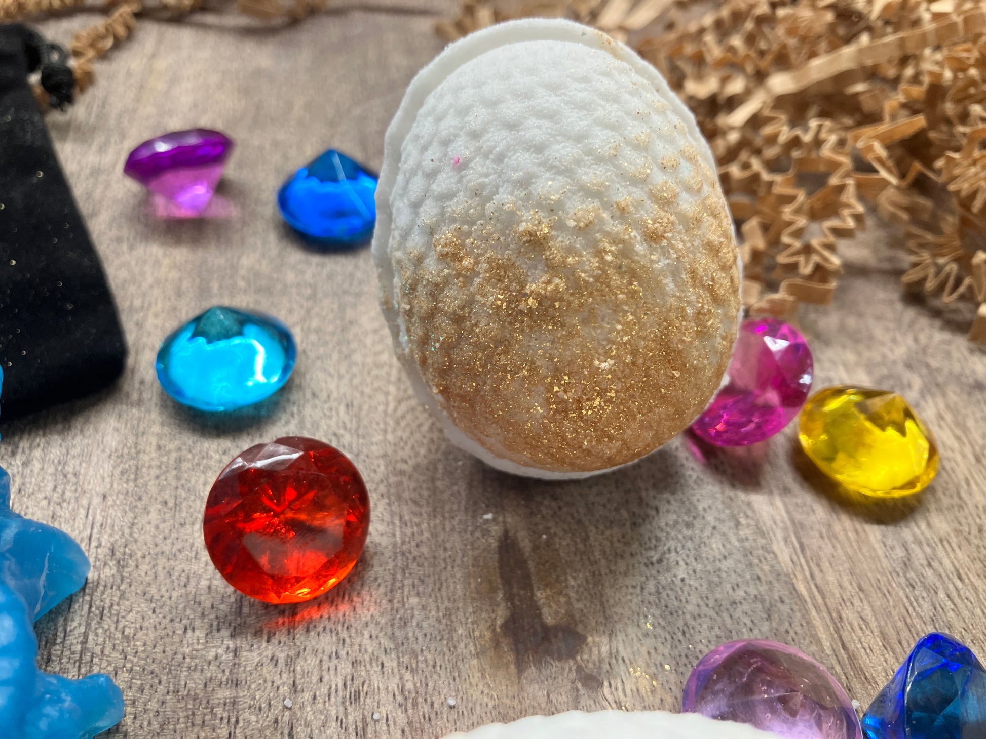 Close up of one dragon egg bath bomb in white with golden base.